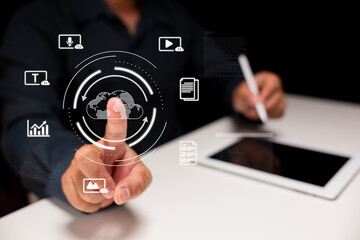 A person interacts with digital cloud technology, using a tablet and pointing at virtual icons representing data and connectivity.