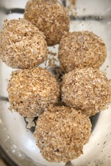 Traditional homemade plum dumplings served in a transparent glass bowl, close-up view.