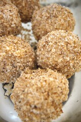 Traditional homemade plum dumplings served in a transparent glass bowl, close-up view.