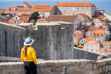 Mujer viajera con sombrero contemplando las vistas de la ciudad de Dubrovnik desde un mirador