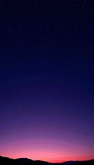 A breathtaking view of the tranquil night sky, transitioning from vivid sunset hues of purple and pink to the deep, star-filled void of the universe above the horizon.