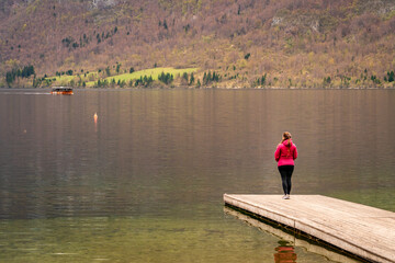 Mujer contemplando en soledad las vistas del lago Bohinj un día de otoño en Eslovenia