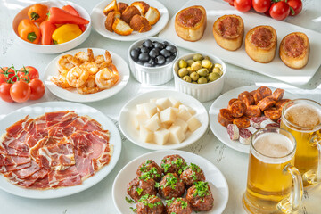 Spanish Tapas Spread with Jamon, Cheese, Shrimp, Olives, and Chilled Beer