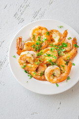 Golden Spanish Fried Shrimps Garnished with Fresh Parsley on White Background Plate