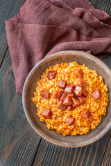 Rustic bowl of spicy tomato and chorizo risotto on wooden table