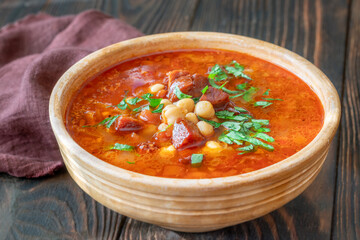 Rustic bowl of Spanish chorizo tomato chickpeas soup topped with cilantro