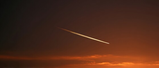 Jet contrail in a colorful sunset sky creating a striking visual contrast over the horizon at twilight