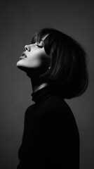 Monochrome portrait woman bob haircut side profile dramatic lighting closed eyes black turtleneck short hair studio shot