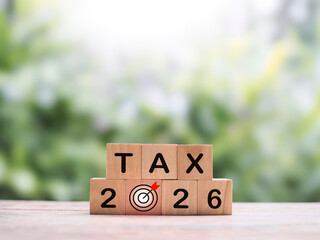 Wooden blocks with the word TAX and number 2026. The concept of prepare to pay tax in year 2026