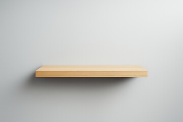 Minimal wooden shelf hanging on clean white wall with soft light shadow creating modern background for creative product display concepts.