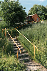 Old Concrete Stairs with Orange Handrails in Countryside