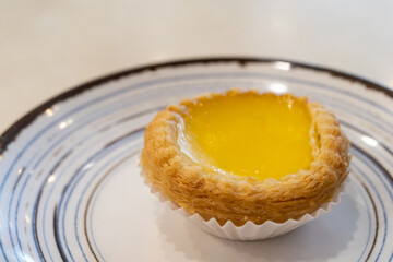 Close up of a freshly baked egg tart on a decorative plate