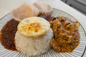 Nasi lemak with curry pork, fried peanut, fried anchovies, sambal and fried egg.