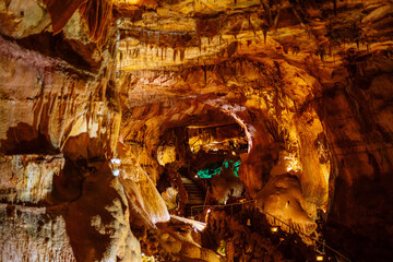 Illuminated Underground Stalactite Cave with Intricate Patterns and Warm Lighting