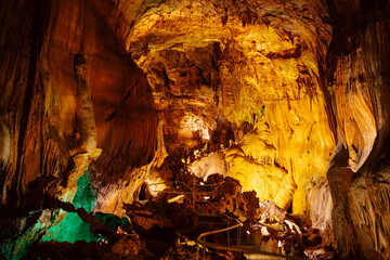 Illuminated Underground Cavern with Stalactites and Natural Formations
