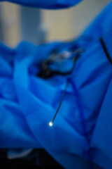 Surgical tools laid out on blue fabric. Medical instruments are organized on a blue surgical drape...