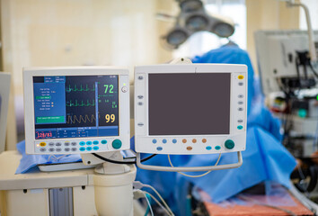 Surgical room medical gear. Medical monitors display vital signs in a well-equipped surgical room...