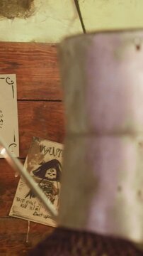 Warrior tears paper of bulletin board in tavern. Medieval knight takes task to catch monster for money on pin-board in pub. Assassin in armour