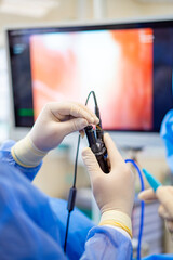 Surgeon using endoscope during procedure. A surgeon skillfully uses an endoscope during a procedure, intently watching the screen for guidance.