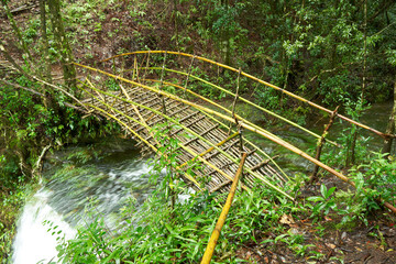 Eco-friendly bamboo bridge over a waterfall