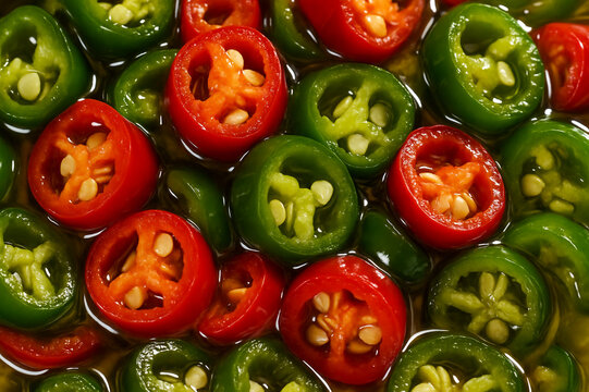 sliced green and red chillies, fresh hot pepper rings for spicy garnish, chilli topping preserved in brine closeup