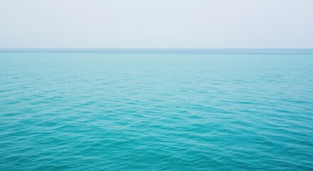 Obraz premium Calm turquoise ocean water with horizon, aerial view