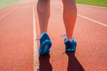 Close-up of a male runner’s feet in athletic sneakers, The athlete is preparing for a jog on an...