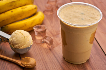 Creamy Peanut Butter and Banana Smoothie with Vanilla Ice Cream in glass side view of healthy drink