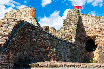 Textured medieval walls and crumbling arches of Czorsztyn Castle with Polish flag on top. A historic and cultural landmark suited for educational materials, tourism campaigns, or architectural backgro © Volha