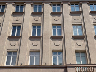 Symmetrical facade with decorative circular ornaments and repetitive window design in Belgrade, Serbia. Architecture, urban tradition, and residential housing expressing rhythm, balance, and cultural