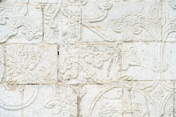 A white old wall with barillefs of stucco. Stone Texture Background with Patterns and Barillefs
