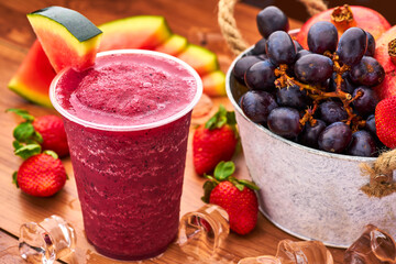 Water Melon, Strawberry, Pomegranate and Grape Smoothie with Fresh Fruit and Ice Cubes in glass side view of delicious refreshment