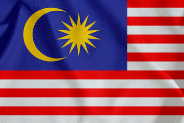 flag of Malaysia with horizontal stripes, crescent moon and star on rough canvas with folds