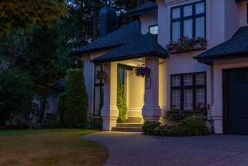 Fototapeta premium Entrance of luxury house with nice green Summer landscape at night in Vancouver, Canada, North America. August 2025.