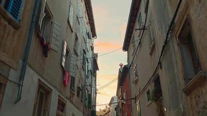 Narrow street of old town Rovinj Croatia with colorful historic houses and shutters, warm evening light illuminating architecture and Mediterranean atmosphere