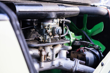 Vintage automobile engine displaying detailed carburetor, vibrant green fan, and intricate mechanical components, embodying classic engineering design and historical preservation
