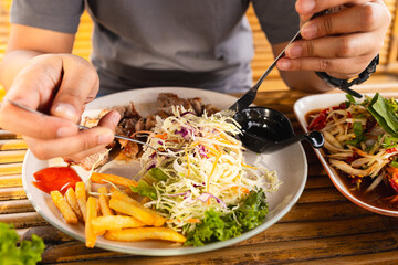 Close-up of a man slicing steak on a plate,Close up of a man eating steak on white plate with fork and knife on his hands,eating stake from plate with fork and knife man hands