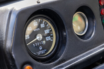 Classic dashboard speedometer shows speed, 53212 kilometers traveled, analog gauges, indicator lights, reflecting enduring vehicle performance, journey