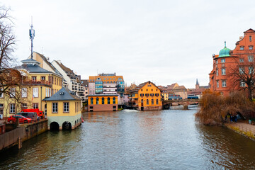 Colmar's riverbanks come alive during the Christmas season, featuring cozy buildings, festive lights, and a tranquil waterway perfect for a holiday stroll.