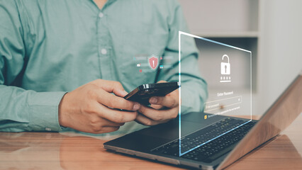 Man using smartphone and laptop with cybersecurity hologram interface. Concept of data protection, online security, encryption, and safe digital communication.
