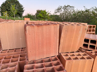 Closeup of stacked red clay bricks ready for construction tile