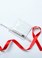 Condoms and red ribbon symbolizing AIDS. World AIDS Day. Vertical photo format