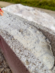 Close-up of weathered concrete block with salt deposit, potentially efflorescence