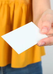 Business card in a female hand close-up. Vertical photo format
