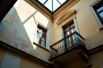 Sunlit courtyard with weathered wrought-iron balcony