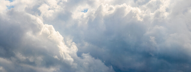 Atmospheric background with dense white and gray clouds in the sky, natural cloud texture for design, abstract and decorative projects