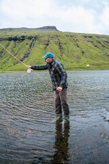 Man Fly Fishing in Mountain Lake on the Faroe Islands