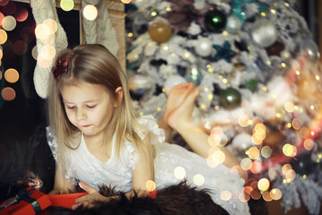 Family on Christmas eve at fireplace. Kids opening Xmas presents. Children under Christmas tree...
