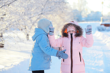 Family with children play snowy winter games in the park. Winter holidays and family vacation....
