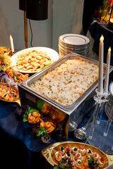 Elegant buffet with various dishes. Catered buffet features flavorful rice, appetizers, and elegant...